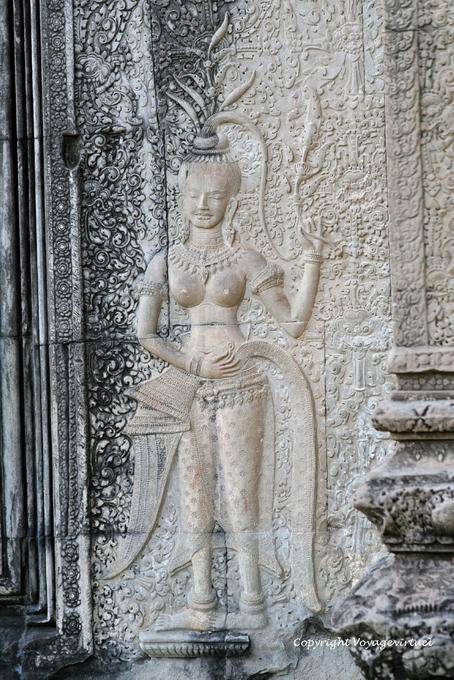 Touching a topless apsara to bring good luck, Angkor Wat, Angkor, Cambodia
