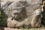Sculpture fragment on a stone placed on the ground, Elephants Terrace, Cambodia.