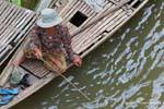Woman fishing from a boat, Chlong, Cambodia.