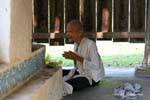 Very old nun praying at Wat Roka Kandal Kracheh (Kratie), Cambodia.
