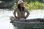 Woman in lotus position on a boat, Tonle Sap Lake, Cambodia.