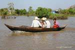 Family in a wooden canoe, Tonle Sap, Cambodia.