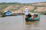 Floating merchant arriving in a village on stilts, Tonle Sap, Cambodia.