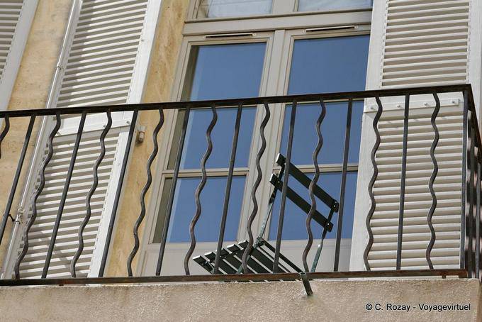 Chair on a wrought iron balcony, Avignon, Provence, France