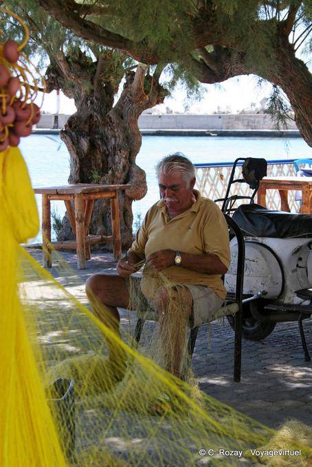 Fisherman sitting along the Cougioumoutzaki, Ierapetra - Crete, Greece
