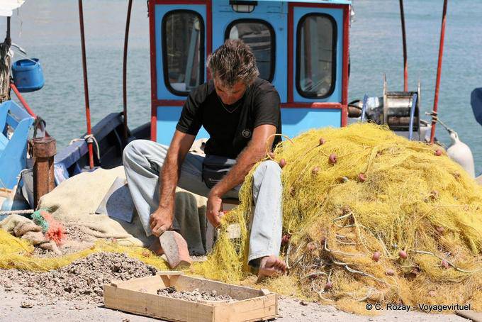 Hammering shellfish caught in the net, Iraklio port (Heraklion) - Crete, Greece