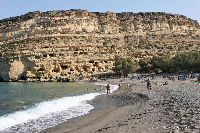 The beach in arch and the protected site of the tomb caves of Matala - Crete, Greece