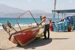 Cretans and his boat before the Kalamaki beach, south of Tymbaki, Crete.