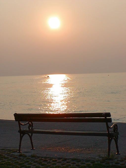 Bench at the water's edge at sunset, Krk, Croatia