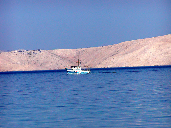 Fishing boat passing by the island Goli Otok, Croatia