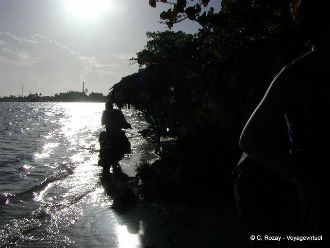 Against the light, motorcycle passing on the waves, Boca Chica, Dominican Rep.