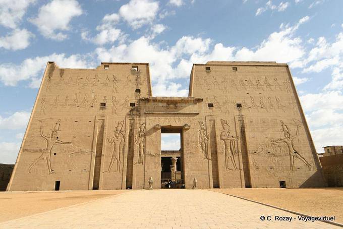Edfu, the imposing facade of the tower guarded by two statues of Horus at the entrance - Egypt