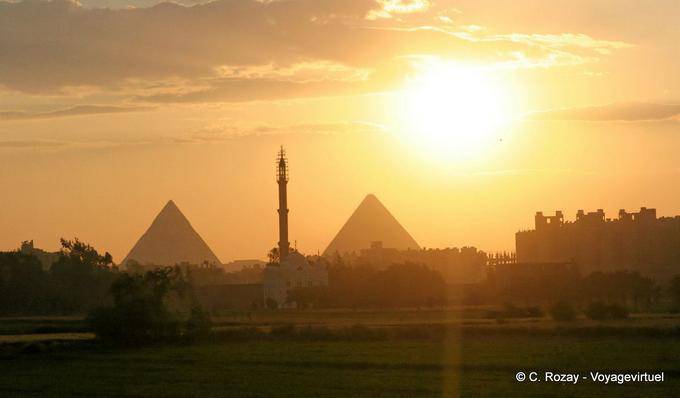 Fabulous sunset over the pyramids flanking the minaret of a mosque, Cairo - Egypt