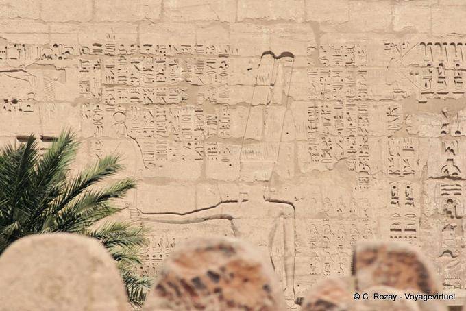 Hieroglyphs and Amun-Re on the first pylon of the Great Temple, Medinet Habu - Egypt