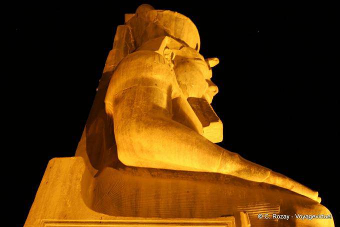 At the foot of Rameses II colossus sitting, night view, Luxor Temple - Egypt