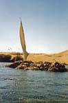 Felucca sailing hidden by an island on the Nile, Aswan, Egypt.