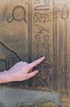 Finger on hieroglyphics, temple of Edfu, Egypt.
