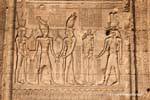 Gods, goddesses and pharaoh holding hands, facade, Esna Temple, Egypt.