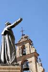 Catholic statue in front of the belfry storks, Salamanca, Spain.