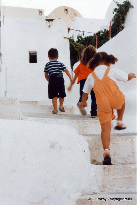 Kids running up the stairs of Chora, Anafi - Greece