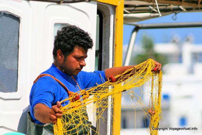 Milos, Pollonia, preparing fishing nets on the harbor - Greece
