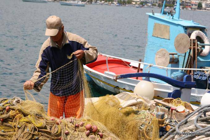 Fisherman and fishing net in port, Poros - Greece