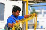 Milos, Pollonia, preparing fishing nets on the harbor, Greece.