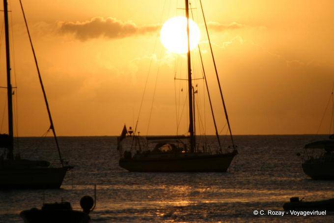 Sun setting behind a sailboat mast, Deshaies - Guadeloupe