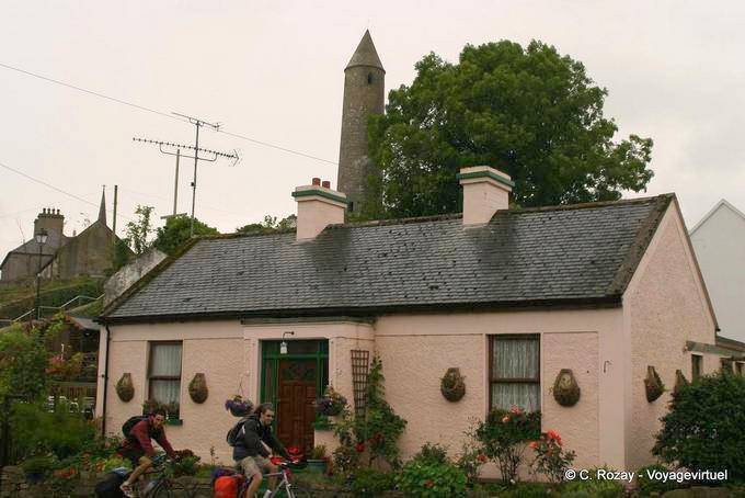 Pink house in front of the tip of the round tower, Killala Mayo - Ireland