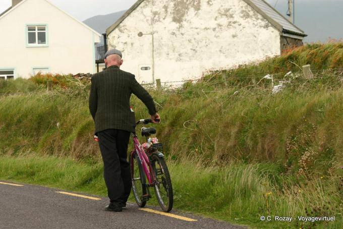 The passing cap pushing his bike, Dingle - Ireland