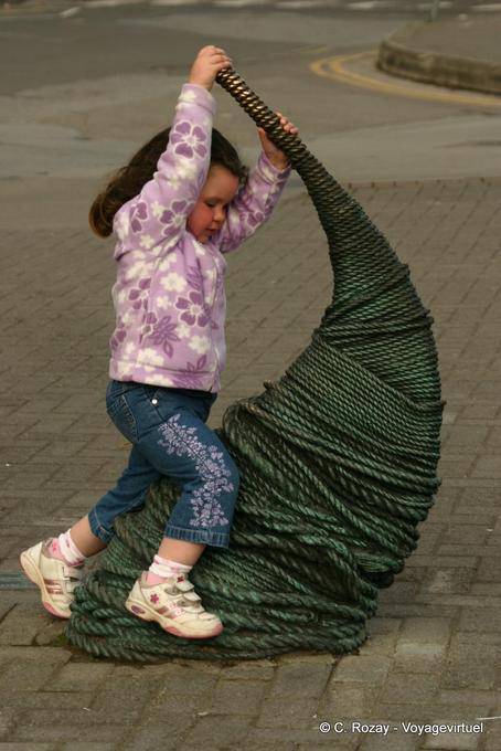 Little girl playing on a sculpture, Dingle - Ireland