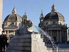 Lion fountain in front of the domes of Santa Maria in Montesanto and Santa Maria dei Miracoli, Piazza del Popolo, Rome, Italy.