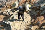The last meters of the ascent of the crater, a carrier with boots, Kawa Ijen, Java, Indonesia.
