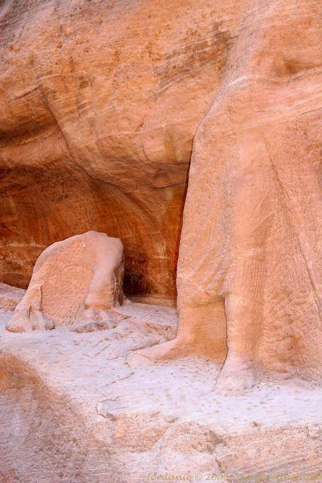 Sculpture of a camel dressed in a tunic and penetrant barefoot in the Siq, Petra - Jordan