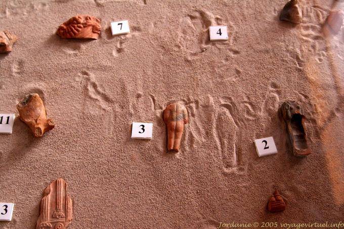 Fragments of sculptures exhibited in the sand of Petra Lower City - Jordan