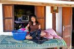 Seamstress front of his house, Ban Xanhai, Lao.