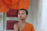 Novice monk seriously in Kuti, Wat Visoun, Luang Prabang, Lao.