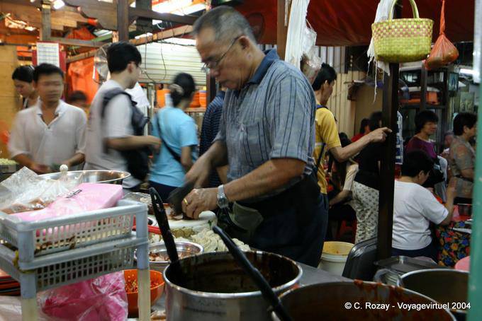 Food preparation in a street restaurant, night market, Kuala Lumpur - Malaysia