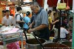 Food preparation in a street restaurant, night market, Kuala Lumpur, Malaysia.