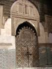 A carved wooden door and stucco Sahrij Medersa, Fes, Morocco.