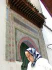 Face in front of a multicolored gate Fes, Morocco.