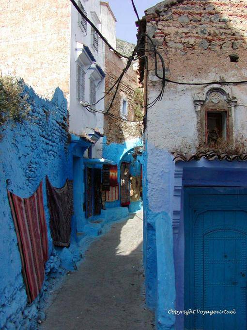 Carpets hanging on the colored wall, Chefchaouen - Morocco