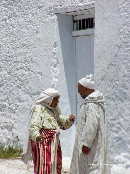 Woman wearing apron skirt mendile and djellaba man, Chefchaouen - Morocco
