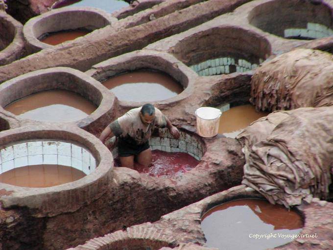 The hard work of the dyer in the tank with ceramic walls, Fes - Morocco