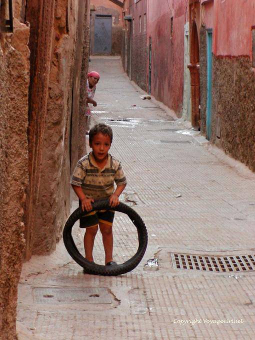 A child playing with a tire alley of the Medina, Marrakech - Morocco