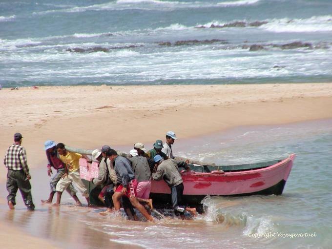 Combined effort of the fishermen to bring the boat on the sand, Oualidia - Morocco