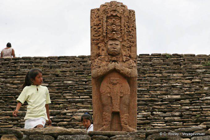 Curious children before the statue of the sixth century representing the sovereign B'alam Ya Acal, Tonina - Mexico