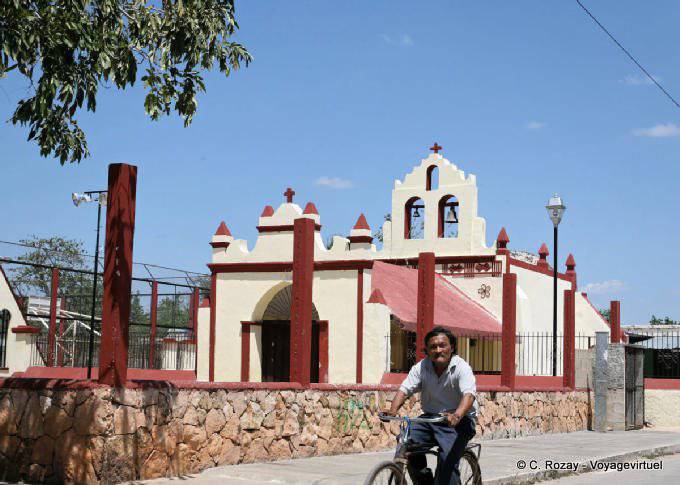 Cyclist passing a church, Yucatan - Mexico