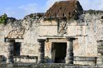 Columns and thatched roof of the structure XXV, Tulum, Mexico.