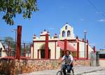 Cyclist passing a church, Yucatan, Mexico.